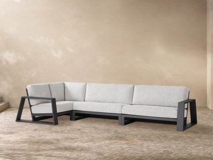 L-shaped Canyon Outdoor Aluminum Three-Piece Sectional with dark grey frame and light grey cushions on a patio.