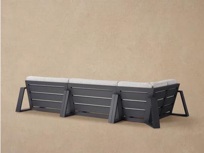 Close-up angled view of a Canyon Outdoor Aluminum Three-Piece Sectional with light gray textured cushions and a dark frame.