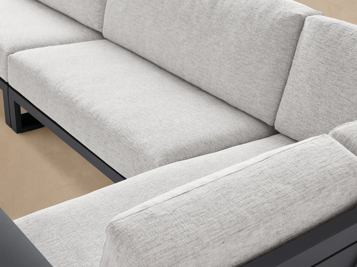 Canyon Three-Piece Sectional with dark gray aluminum frame & light gray cushions, L-shaped on an outdoor patio.