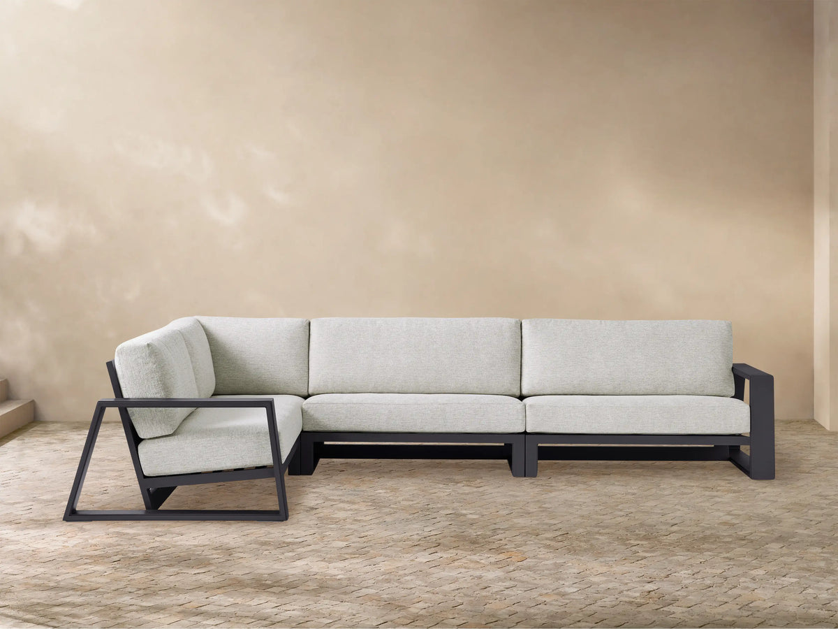Modern L-shaped Canyon Outdoor Aluminum Three-Piece Sectional with dark gray frame & light gray cushions, on a patterned patio.
