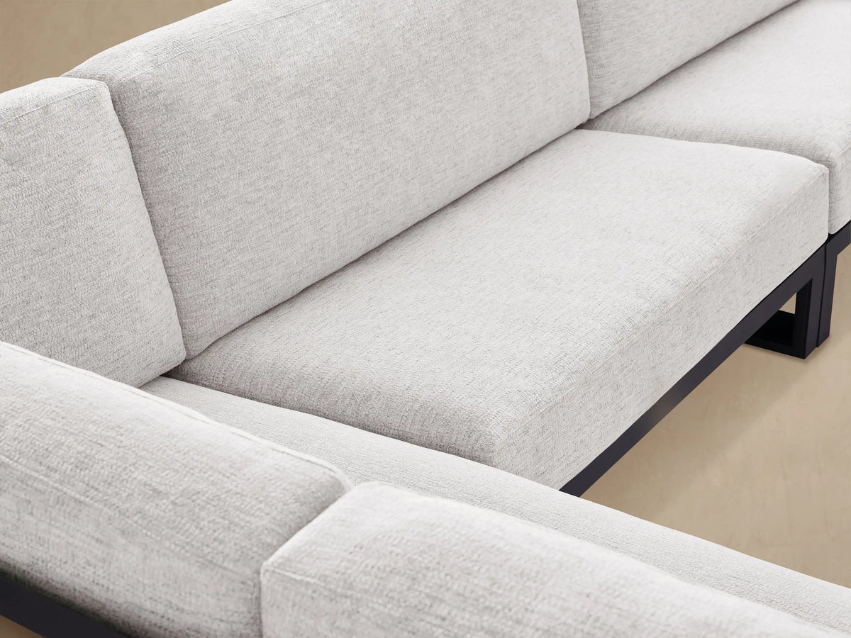 Canyon Outdoor Aluminum Three-Piece Sectional with dark gray frame and light gray cushions, L-shaped on a patio.