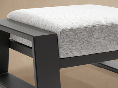 Canyon Outdoor Aluminum Ottoman with a geometric dark gray frame and textured light gray cushion on a patio.