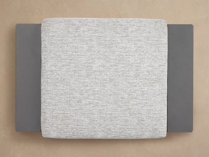 Canyon Outdoor Aluminum Ottoman, featuring a light gray textured cushion resting on a dark gray, powder-coated aluminum frame.
