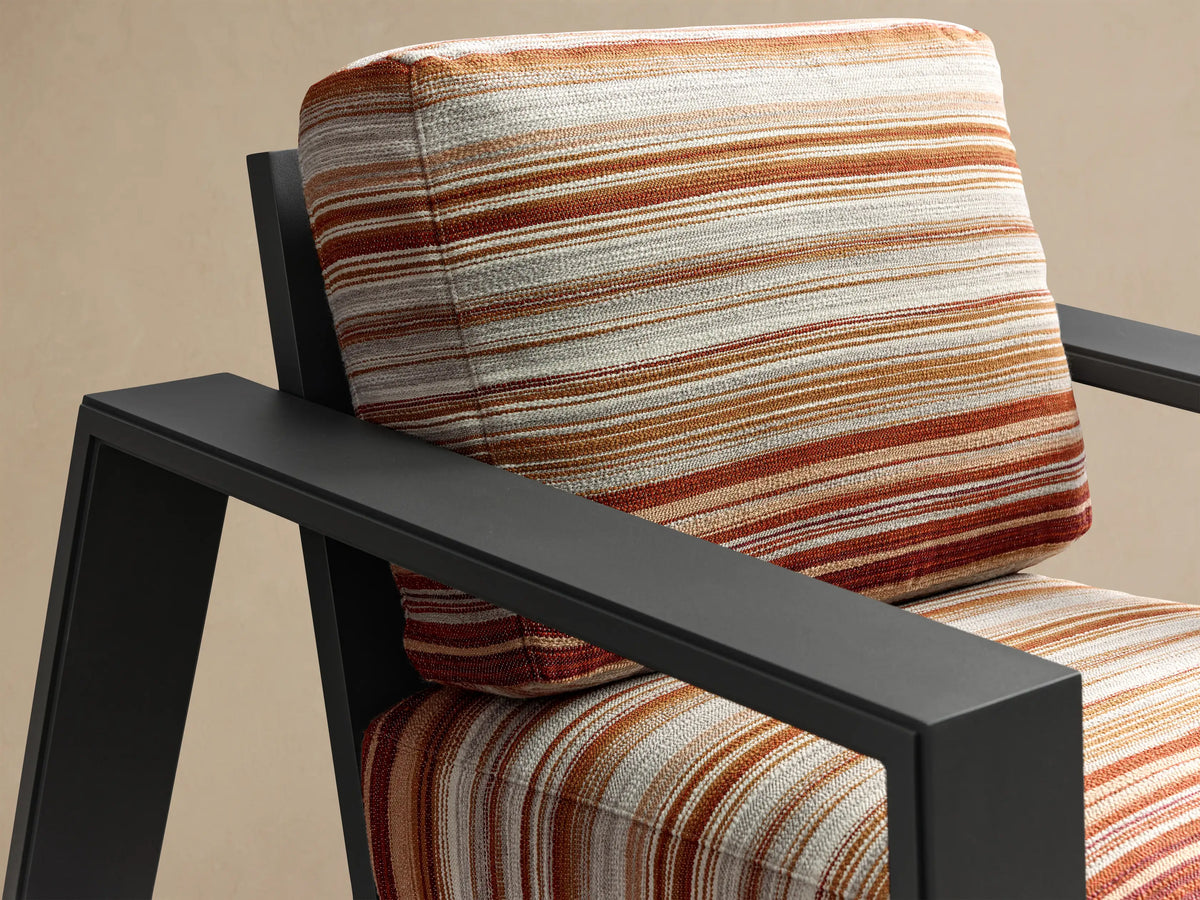 Close-up of the black aluminum armrest and terracotta striped cushions on the Canyon Outdoor Aluminum Lounge Chair.