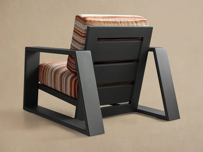 Front view of the Canyon Outdoor Aluminum Lounge Chair with dark gray frame and striped red, orange, beige cushions.