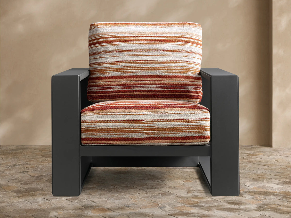 Rear view of the Canyon Outdoor Aluminum Lounge Chair with a black frame and striped cushions in orange, cream, and brown.