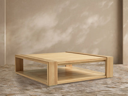 Canyon Outdoor Teak Coffee Table, rectangular, natural light wood, thick block legs, slatted lower shelf, on stone patio.