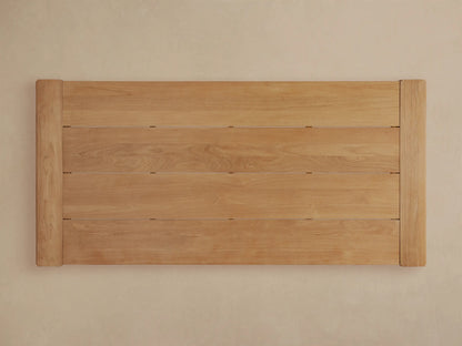 Front view of the natural teak Canyon Outdoor Teak Dining Table with slatted top and thick block legs.
