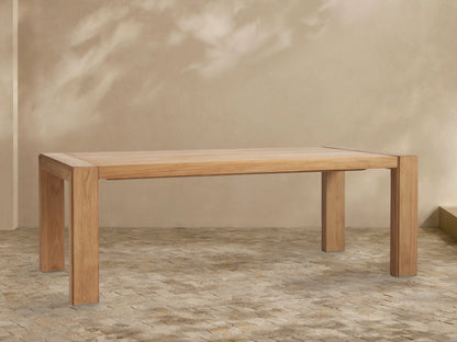 Close-up of the light brown Canyon Outdoor Teak Dining Table corner, featuring plank top, visible wood grain, and grooved leg.