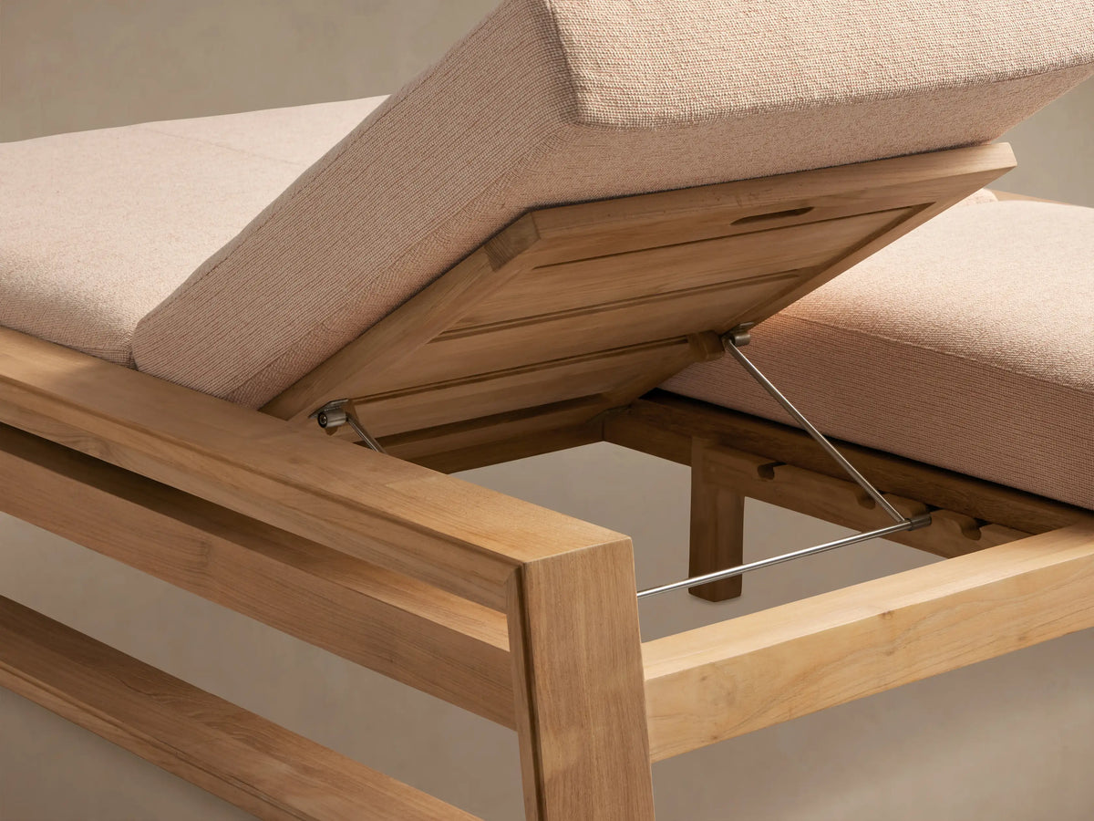 Canyon Outdoor Teak Double Chaise. Side view of one section with light teak wood frame, raised back, and light beige cushions.