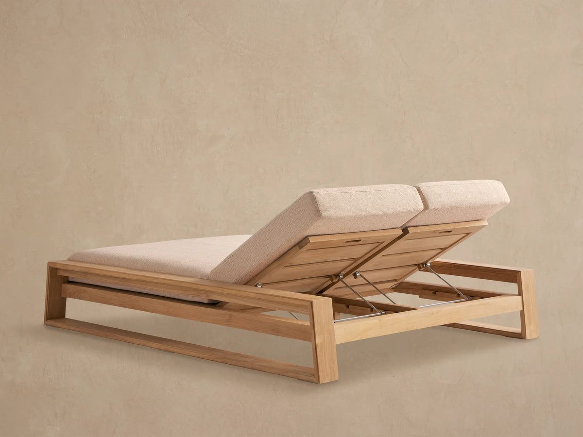 Canyon Outdoor Teak Double Chaise, close-up. Light beige cushion on raised teak wood backrest, showing adjustable metal mechanism.