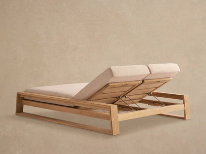 Canyon Outdoor Teak Double Chaise, close-up. Light beige cushion on raised teak wood backrest, showing adjustable metal mechanism.