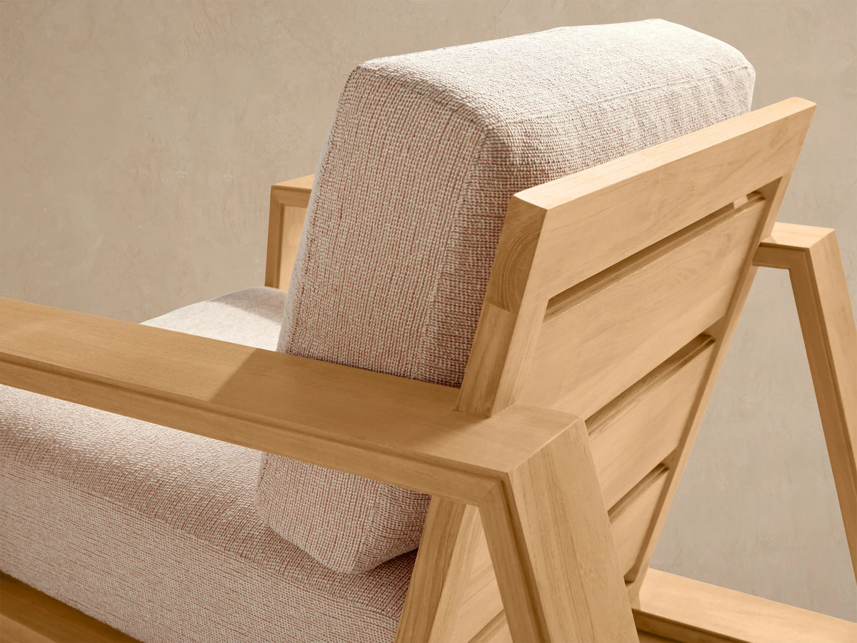 Front view of Canyon Outdoor Teak Lounge Chair with a light teak wood frame and thick light beige seat and back cushions.
