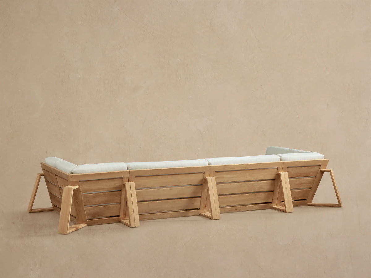 Canyon Outdoor Teak Sectional, close-up of natural golden wood armrest & frame with light cream back & seat cushions.