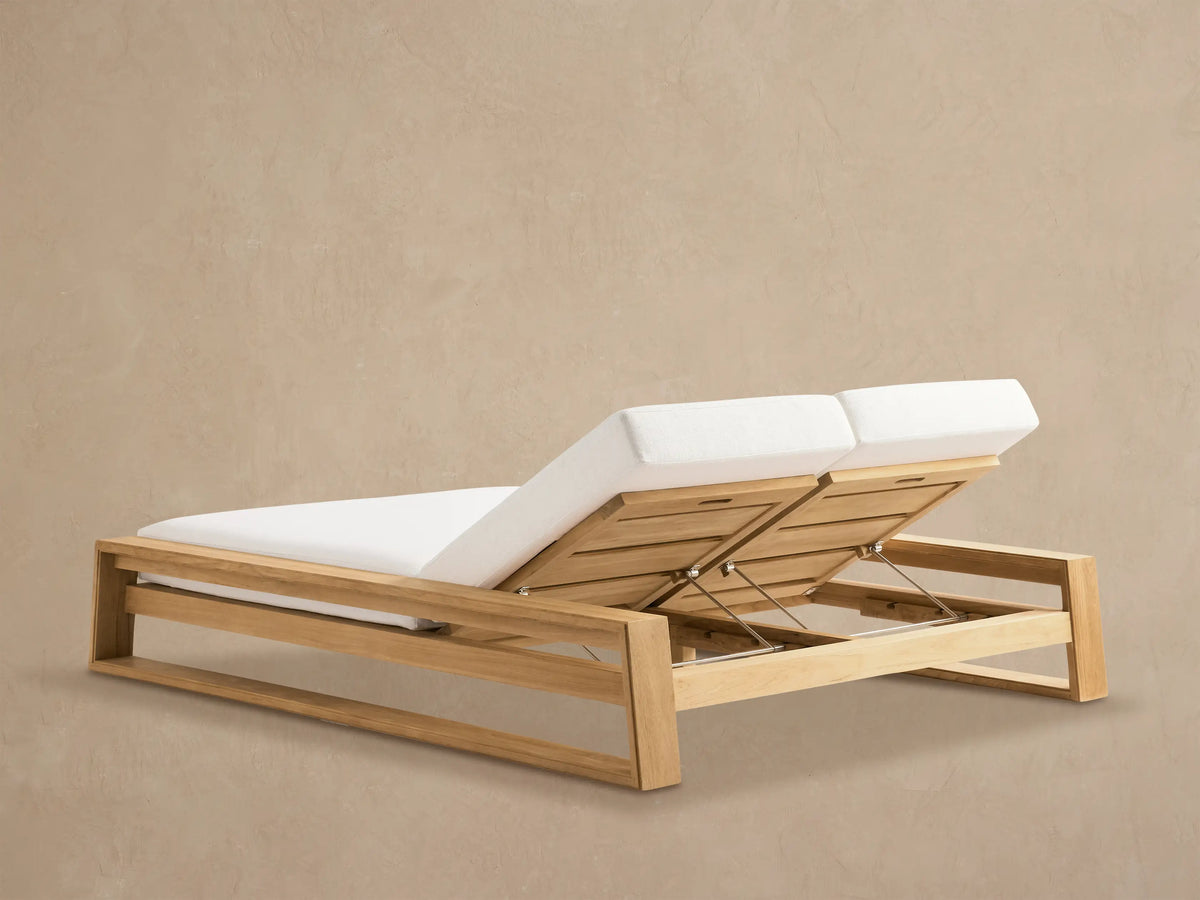 Close-up of Canyon Outdoor Teak Double Chaise with one raised adjustable backrest and white cushion, showing the teak wood frame and metal hinge mechanism.