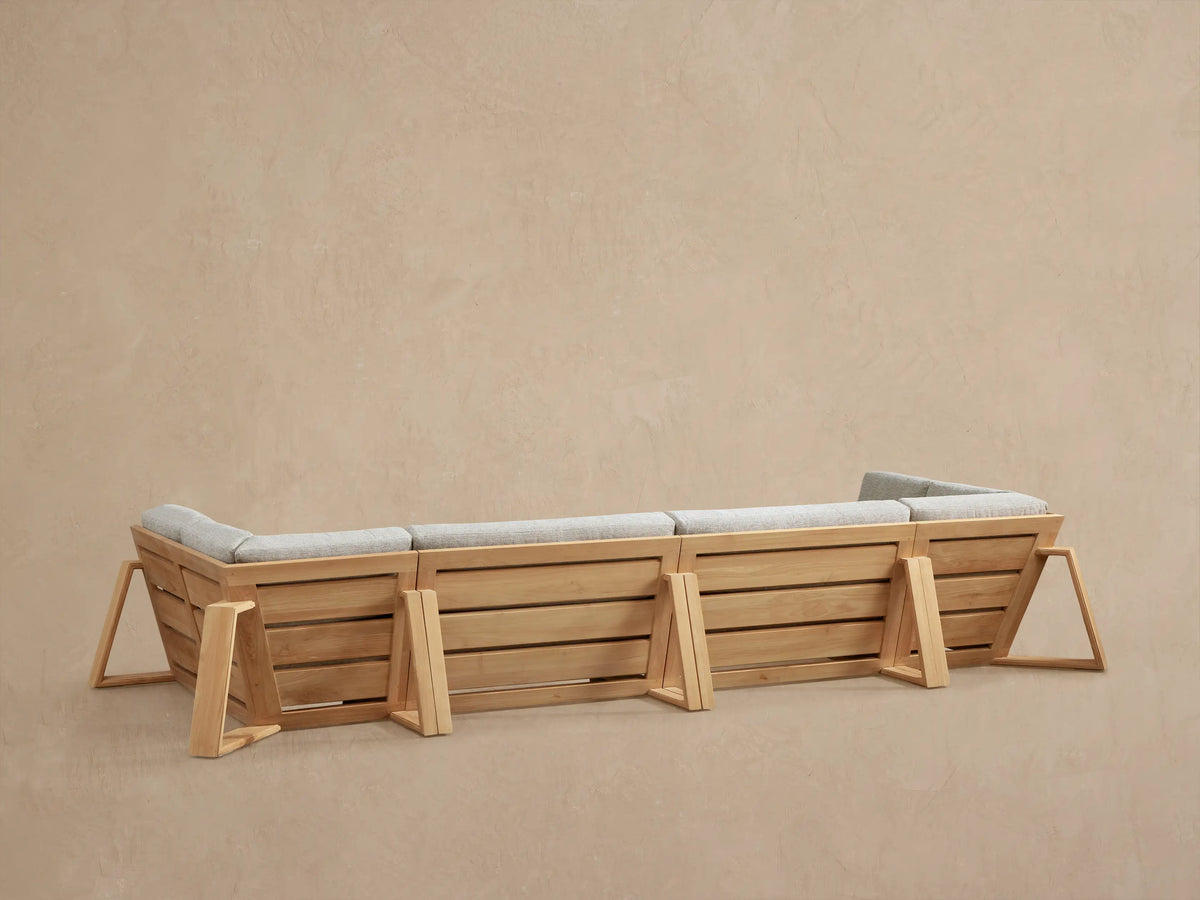 Canyon Outdoor Teak Sectional: Angled close-up showing light brown slatted teak armrest & back with light grey woven cushions.