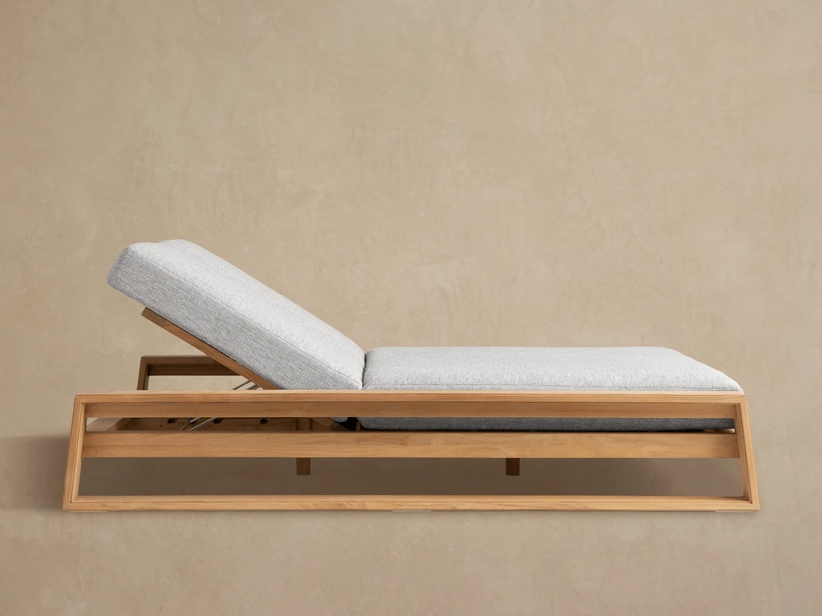 Canyon Outdoor Teak Double Chaise with natural teak frame and light grey cushions, backrests raised, on a patio.