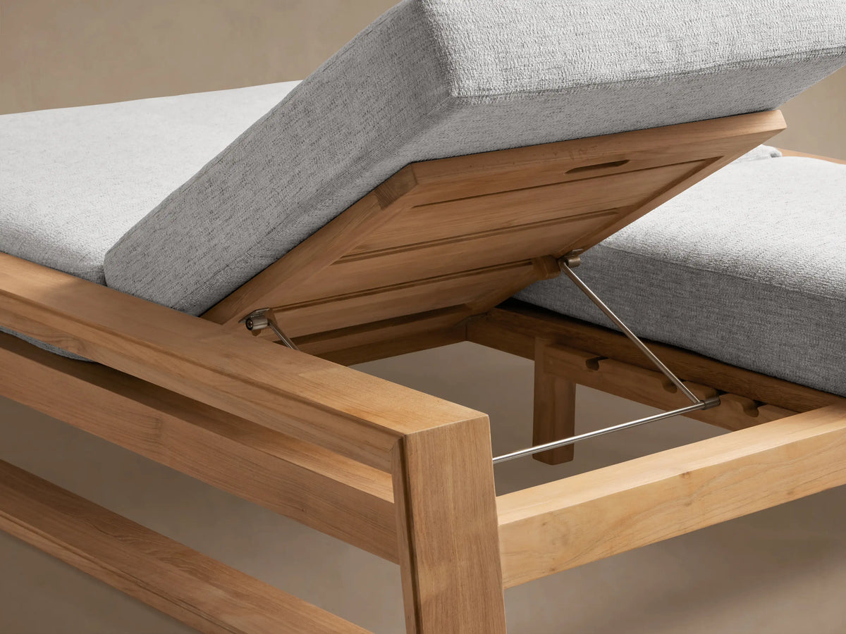 Side view of Canyon Outdoor Teak Double Chaise with light grey cushions. One backrest is raised, the other flat. Teak wood frame.