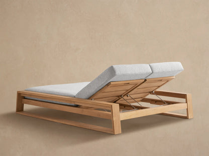 Close-up of Canyon Outdoor Teak Double Chaise with one light grey cushioned back raised, showing the teak wood frame and metal adjustment arm.