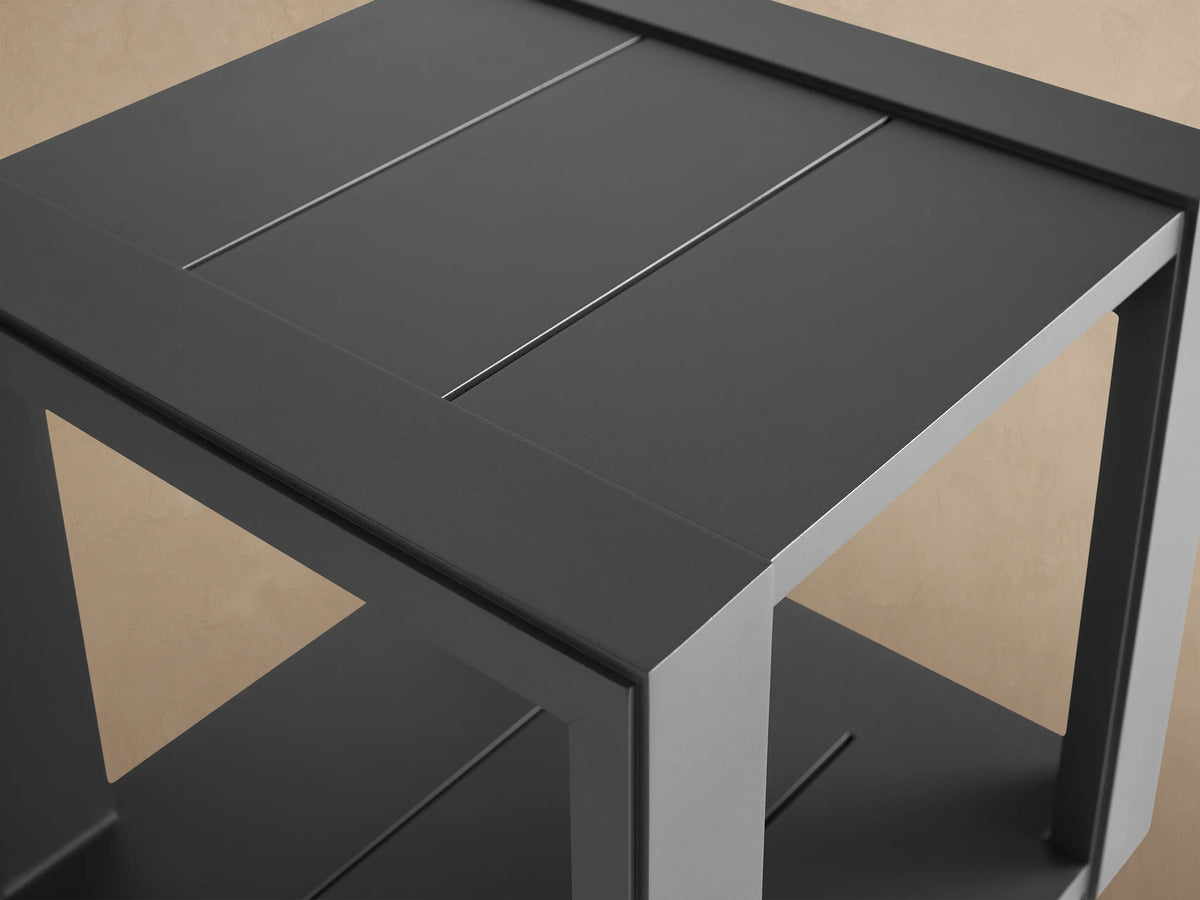 Lava grey Canyon Outdoor Aluminum End Table, square, with panelled top & bottom shelf, on a stone patio.