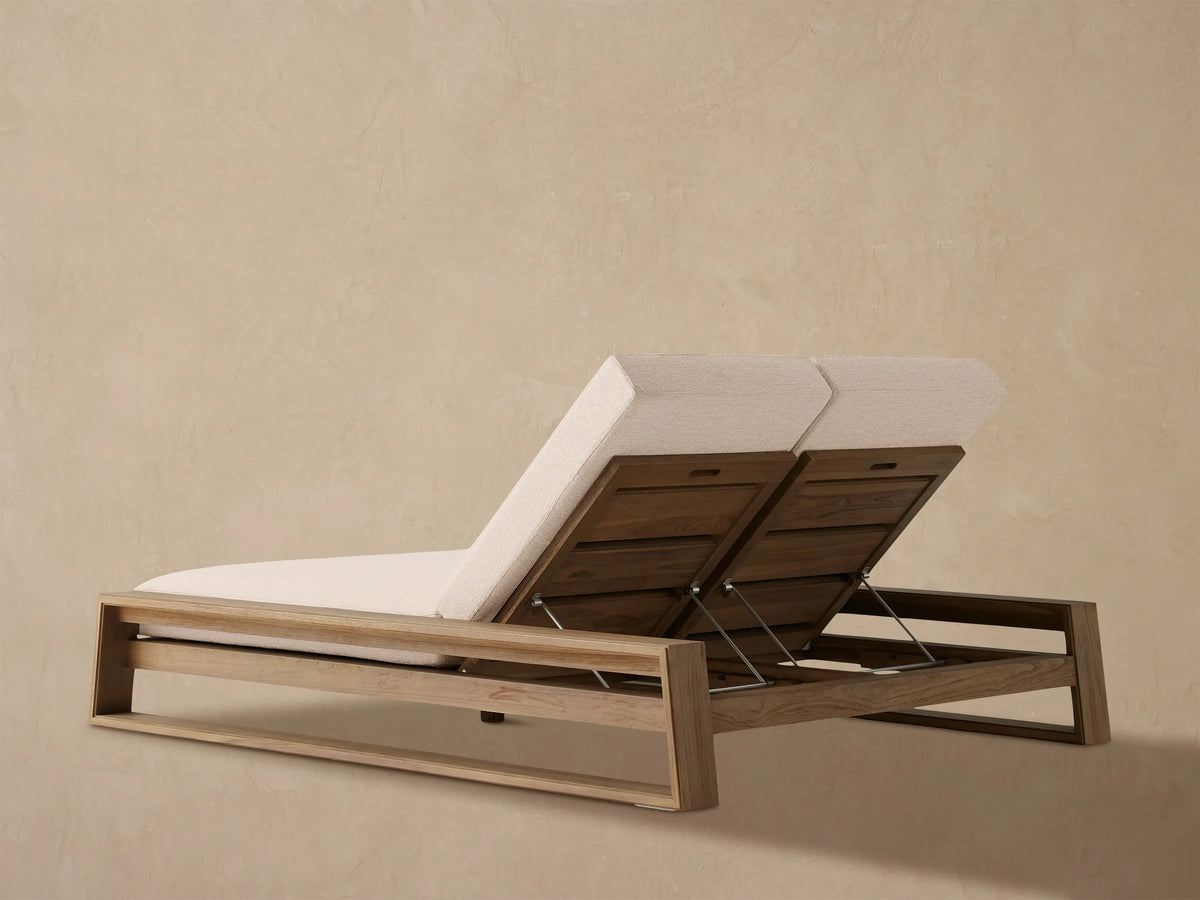 Close-up of the Canyon Outdoor Teak Double Chaise, showing two raised teak backrests with beige cushions and silver adjustment rods.