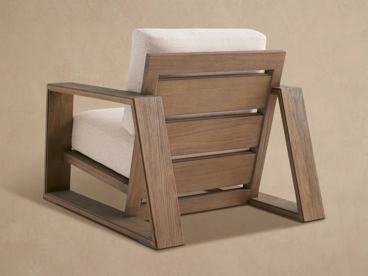 Canyon Outdoor Teak Lounge Chair: close-up, angled view of medium brown wood frame & light beige textured cushions.