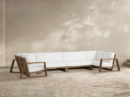 Canyon Outdoor Teak Four-Piece Sectional, modern brown teak open frames with thick white cushions, on a stone patio.