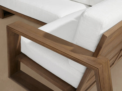 Canyon Outdoor Teak Four-Piece Sectional: L-shaped sofa, two armchairs with natural wood frames & white cushions.