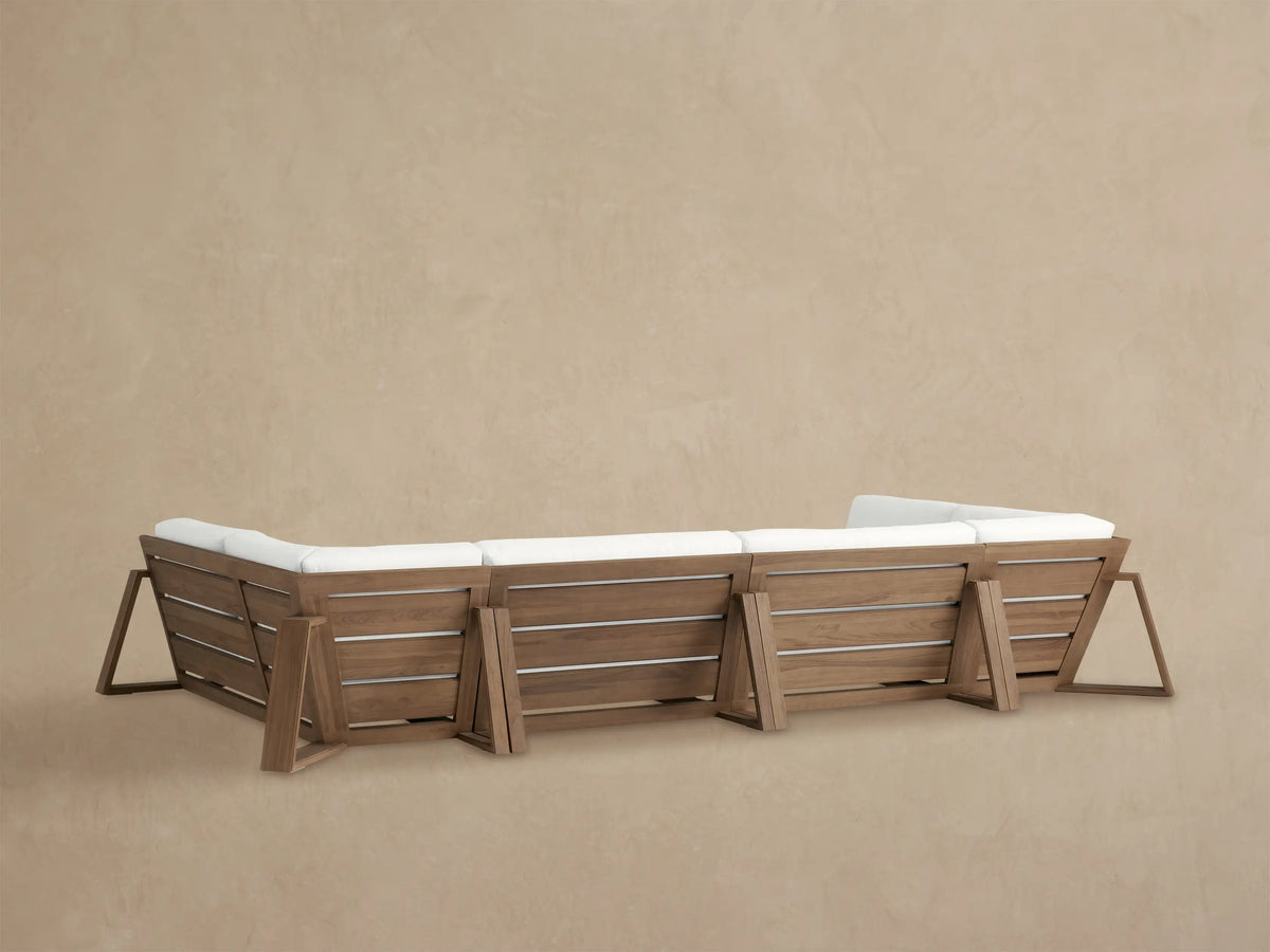Close-up of Canyon Outdoor Teak Sectional armrest & backrest with white cushions, showing weathered fawn teak wood grain.