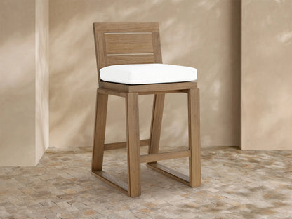 Canyon Outdoor Teak Barstool angled right: light brown teak with square back, white cushion, sturdy legs on mosaic tile.