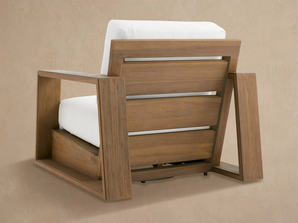 Close-up of Canyon Outdoor Teak Swivel Chair armrest, showing textured brown teak wood frame and plush white cushions.
