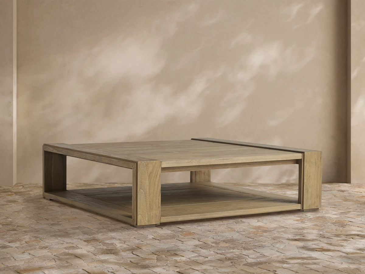 Canyon Outdoor Teak Coffee Table, light natural wood, slatted rectangular top, chunky legs, and a lower storage shelf.