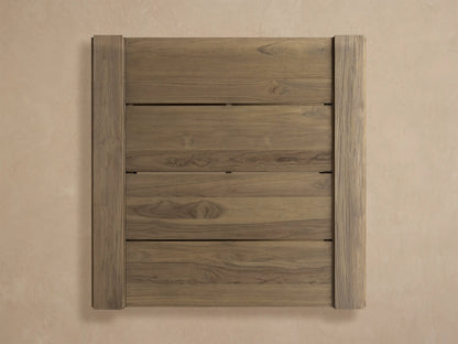 Canyon Outdoor Teak Coffee Table. Square, weathered teak with slatted top & lower shelf, on a rustic tiled patio.