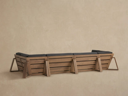 Close-up of Canyon Outdoor Teak Four-Piece Sectional showing light brown teak armrest and dark grey cushions.