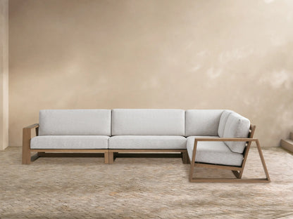 Canyon Outdoor Teak Three-Piece Sectional, L-shaped, with light grey cushions & natural teak wood frame, on a patio.