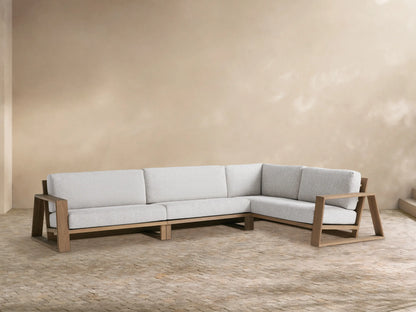 Canyon Outdoor Teak Three-Piece Sectional, L-shaped, with light grey cushions & natural teak wood frame, on a patio.