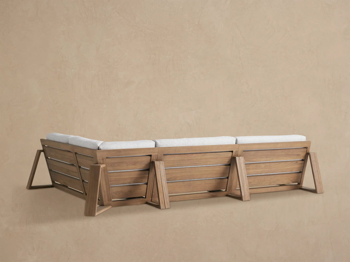 Close-up of Canyon Outdoor Teak Sectional with light gray textured cushion against a weathered teak wood armrest.