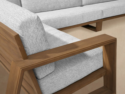Canyon Outdoor Teak Four-Piece Sectional, U-shaped, with weathered teak frame and light grey cushions on a paved patio.