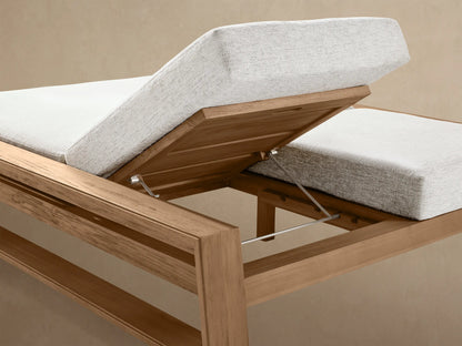Canyon Outdoor Teak Double Chaise with light natural teak wood frame, light gray cushions, and raised backrest, side view.