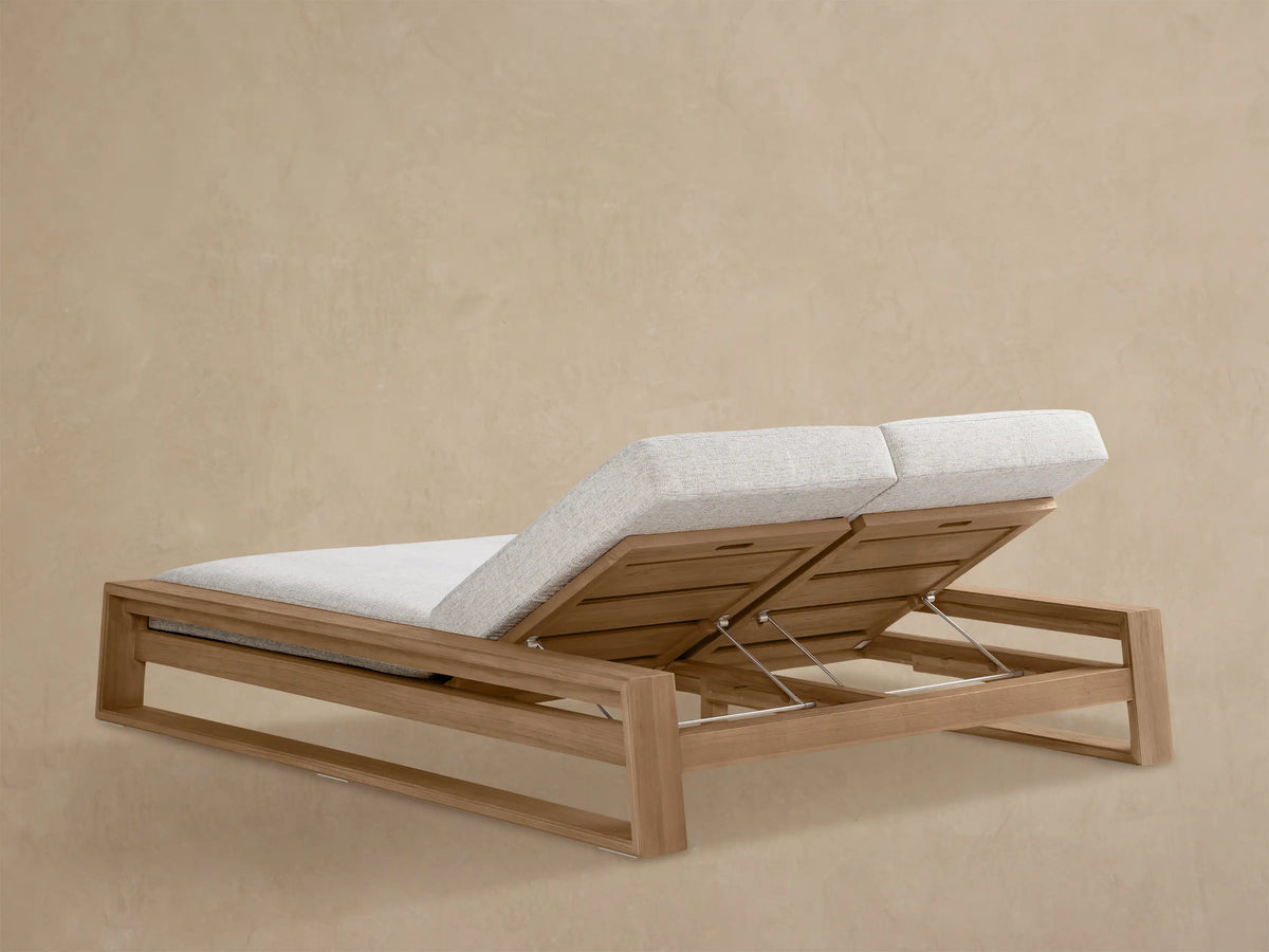 Canyon Outdoor Teak Double Chaise. Close-up shows light grey cushion on raised teak backrest with metal adjustment arm.