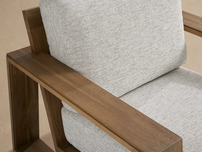 Front view of Canyon Outdoor Teak Swivel Chair with natural teak frame & light gray Shardai Zinc fabric cushions on stone floor.