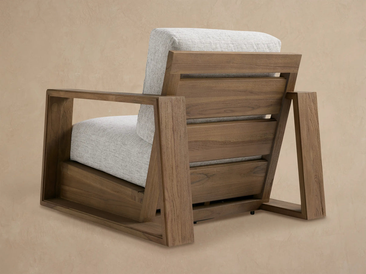 Close-up of Canyon Outdoor Teak Swivel Chair, showing smooth teak armrest & light gray Shardai Zinc cushions.