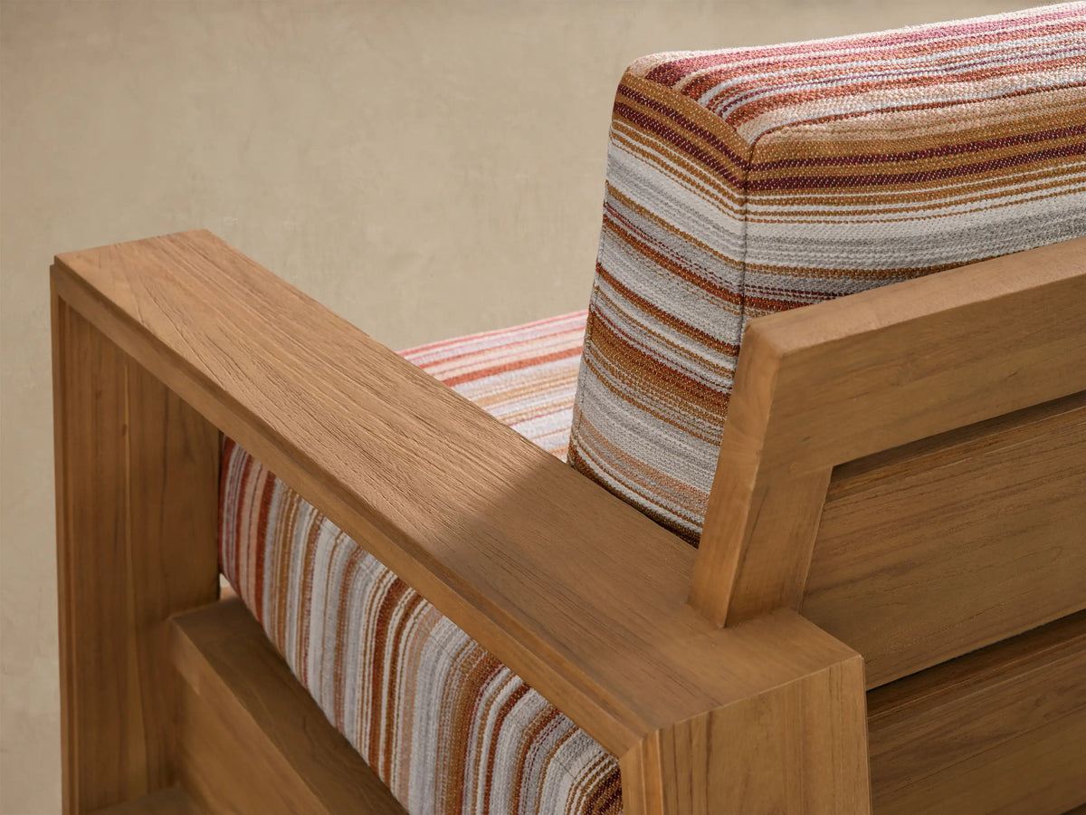 Canyon Outdoor Teak Swivel Chair, front view. Natural teak wood frame with blocky arms, striped seat and back cushions in warm tones.
