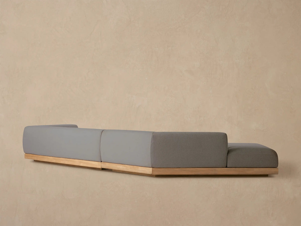 Close-up of dark grey textured fabric on the Carmel Outdoor Two-Piece Bumper Sectional's armrest and seat cushion.
