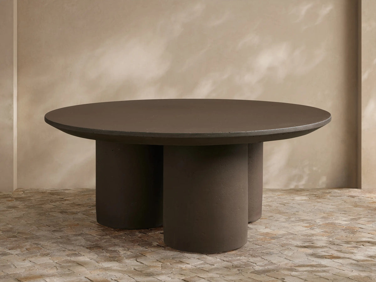 Two cream Cascade Outdoor Coffee Tables with column legs and reverse-beveled tabletop edges, arranged on a patio rug.