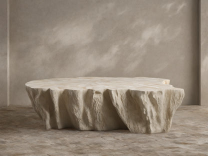 Clayhill Outdoor Coffee Table, light beige, with a rugged, tree-trunk-like fiberglass base and irregular, textured tabletop.