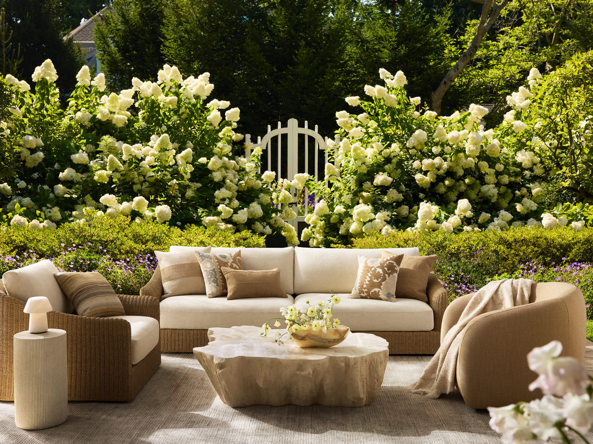 Clayhill Outdoor Coffee Table, light beige, with a rugged, tree-trunk-like fiberglass base and irregular, textured tabletop.