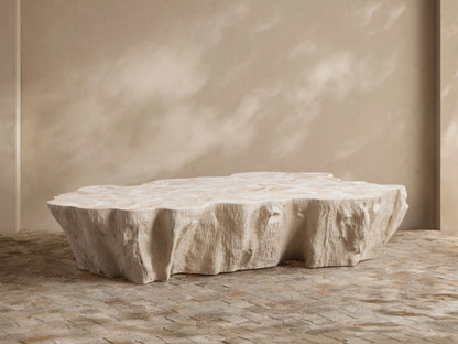 Light, organic-shaped Clayhill Outdoor Coffee Table with a textured top, central on a patio with natural woven seating and white hydrangeas.