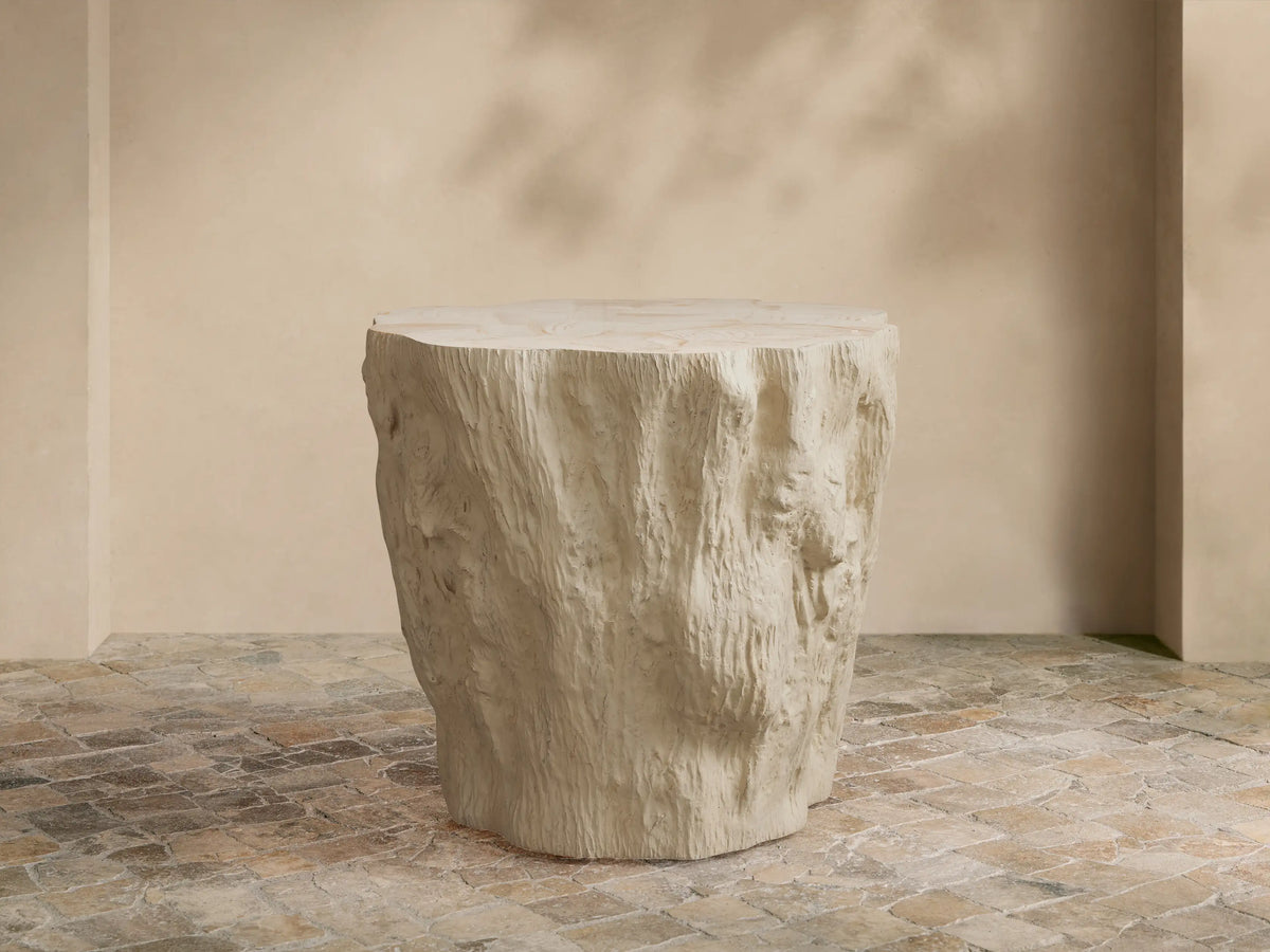 Clayhill Outdoor Tapered End Table, light beige, textured tree stump design, on a patterned stone patio floor.