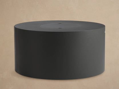 Coden Outdoor Round Propane Fire Pit, dark gray cylindrical design, with black lava rock inside, on a patio.